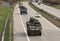Strykers,wheeled armored vehicles drive on highway .