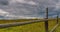 Stubble field with straw bales under blue sky with cirrus clouds. 4k timelapse 4096x2160