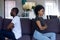 Stubborn black couple sitting on couch ignoring each other