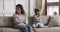 Stubborn mother and child daughter turn back sit on couch