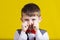 Stubborn,sad,upset little boy,child isolated over yellow backg