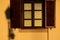 Stucco exterior wall elevation detail with brown stained wooden window and shutters