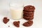 Stuck of chocolate brownie cookies and glass of coconut milk on wooden background. Homemade pastry