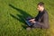 Student boy person work on tablet, computer in summer park. Online man in nature outside. Laptop outdoor business