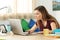 Student browsing content in a laptop in her room