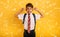 Student Child covers his ears because he does not want to hear noise. Yellow background