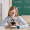 Student in classroom peering into microscope