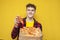 student eats pizza on a yellow background, curly guy advertises fast food and smiles