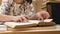 Student female reads book and writes information in notebook in university library