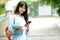 Student girl holding books and using smartphone, online education, technology communication