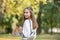 Student girl outside in summer park smiling happy. female college or university student. young woman model wearing school bag