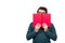 Student guy hiding behind a red book, looking suspicious aside isolated on white background with copy space. Scared nerd person,