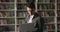 Student guy standing in library with laptop