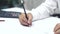 Student hands writing on a book with pencil