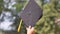 Student hold hats in hand during commencement success on yellow background