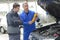 Student with instructor repairing car during apprenticeship