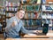 Student with laptop showing thumbs up in the university library