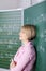 Student leaning against the blackboard