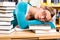 Student in library asleep over books