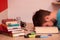 Student passed out in the middle of a big book while studying