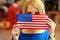 Student peeking behind flag of USA