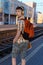 a student poses at a railway station, a teenage boy walks along the platform to the train, he has a backpack and books, goes to