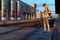 a student poses at a railway station, a teenage boy walks along the platform to the train, he has a backpack and books, goes to