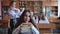 A student poses with textbooks at her desk in her class.