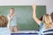 Student raising hand in classroom