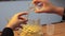 The student's hands dripping a chemical solution into a test tube close-up.