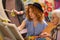 Student sitting near aged teacher and friend coloring picture