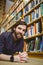 Student smiling on floor in library wearing smart watch