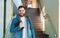 Student on stairs. Portrait caucasian smiling handsome bearded man with backpack notebooks in reopen university campus hallway.