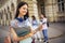 Student standing with her note-book while her friends are studying behind her