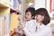 Student and Teacher Taking Book from a Bookshelf