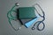 Student textbooks and stethoscopes on grey background, top view.