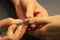 A student at the training courses of a manicure prepares the hand of a lady client with tool for scraping scraper before