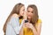 Student whispering to her friend who\'s texting on her phone