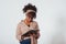 Student writes on the notepad. Beautiful afro american girl with curly hair in the studio with white background