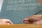 Student writing a note follow details on black board in classroom