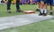 Students boy prepare for long jump competition at school sports day by put legs on chalk