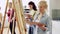 Students with easels painting at art school