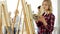 Students with easels painting at art school