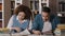 Students guy and girl classmates are sitting in library intently looking for necessary information in textbook working