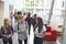 Students holding tablets and phone talk in university lobby