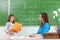 Students read a woman teacher at the blackboard