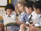 Students Reading Book Sitting In Classroom