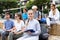 Students record lecture while sitting on a stone street parapet