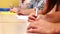 Students sitting in a line taking notes in classroom