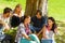 Students sitting in park talking smiling teens